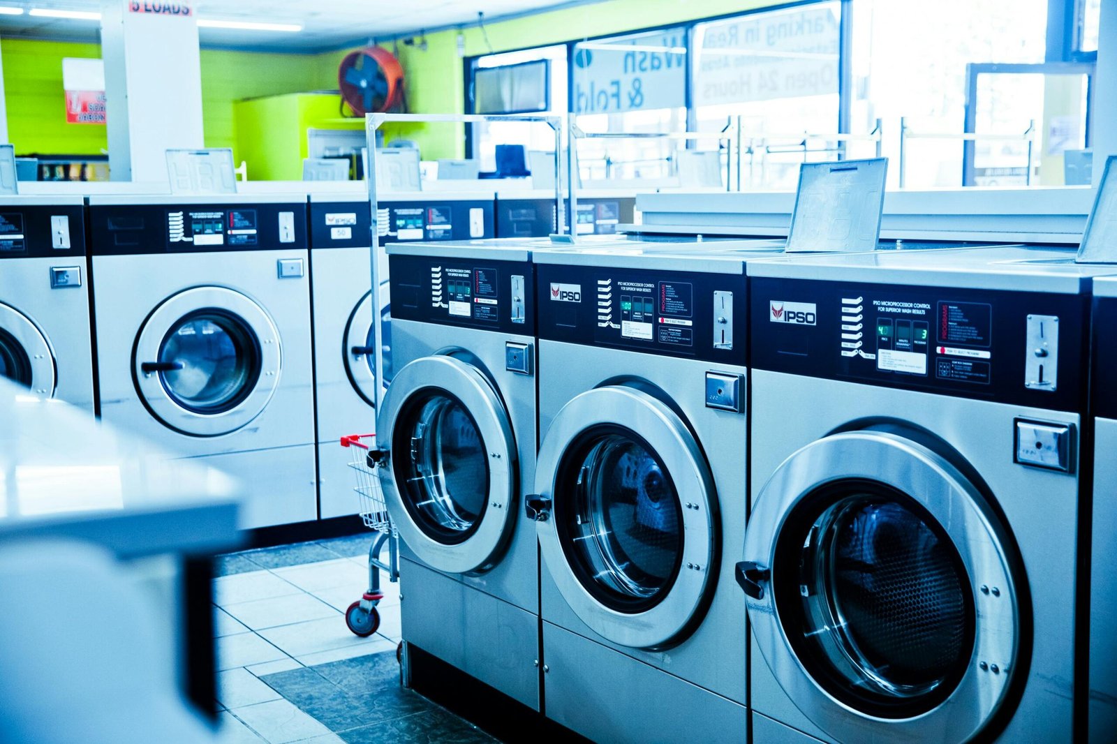 Contemporary laundromat showcasing a row of industrial washing machines for public use.